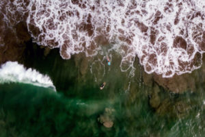 Drone photo of surfers in the waters of playa Langosta Beach